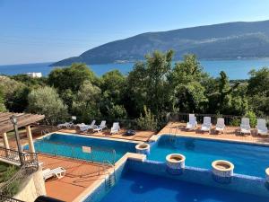 ein Schwimmbecken mit Blick auf das Wasser in der Unterkunft Adria Montenegro Seaview in Herceg-Novi