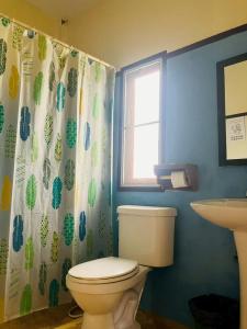 a bathroom with a toilet and a shower curtain at Pai Do See Resort - ปาย ดูร์ ซี รีสอร์ท in Pai +21 photos