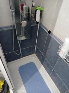 y baño con ducha y suelo de baldosa azul. en Habitación 1 en piso compartido con acceso Zonas comunes, en Marbella