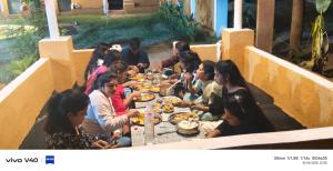 een groep mensen die rond een tafel zitten en eten bij Desert night culture resort in Pushkar