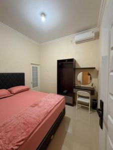 普禾加多patangpuluh homestay的一间卧室，配有一张床和一张带镜子的书桌