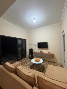 普禾加多patangpuluh homestay的客厅里有一张沙发和一张桌子。