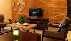 ChicxulubCasa Bul-Kay's - Where Confort Meets Consierge Care的一间客厅,在砖墙上配有电视