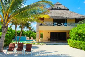 a couple of chairs and a house on the beach at Casa Bul-Kay's - Where Confort Meets Consierge Care in Chicxulub