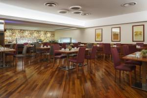 a restaurant with wooden floors and tables and chairs at Exe Majestic in Naples