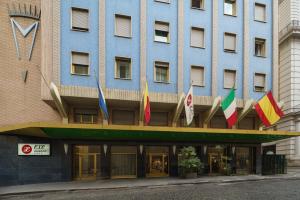 un edificio azul con banderas delante en Exe Majestic, en Nápoles