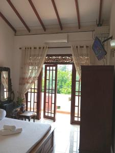 a kitchen with doors open to a living room at Kiyara Holiday Villa in Ambalangoda