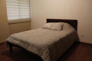 a small bed in a bedroom with a window at Departamento La República in Cuenca +5 photos