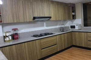 a kitchen with wooden cabinets and a counter top at Departamento La República in Cuenca
