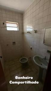 a bathroom with a toilet and a sink at Pousada cosmo in Uberaba