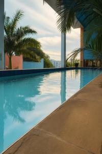 a swimming pool with palm trees on a building at Fairview Signature Suites in Dar es Salaam