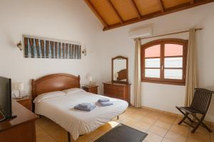 a bedroom with a bed and a mirror and a chair at Villa Corralejo Beach in Corralejo +27 photos