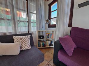 a living room with a couch and a book shelf at Villa Corralejo Beach in Corralejo