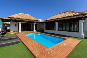 a house with a swimming pool in the yard at Villa Corralejo Beach in Corralejo