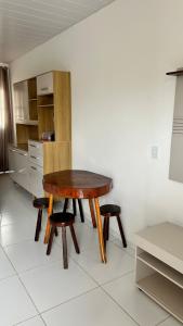einen Holztisch und zwei Hocker in der Küche in der Unterkunft Casa para o Natal in Garanhuns