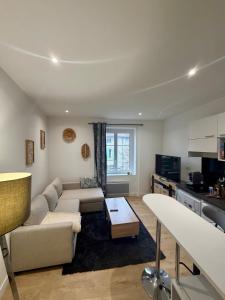 a living room with a couch and a table at Harmony in Limonest