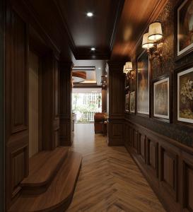 a hallway with wooden floors and paintings on the walls at KAS Luxury Hotel in Ho Chi Minh City