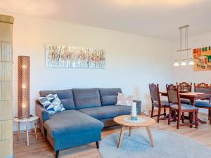 a living room with a blue couch and a table at FeWo Feldblick in Rutenberg