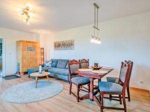 a living room with a table and a blue couch at FeWo Feldblick in Rutenberg