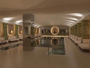 a hotel lobby with a swimming pool and chairs at Conrad Hamburg in Hamburg