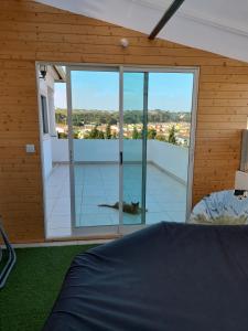 a bedroom with a bed and a large glass window at Villa Jopati in Olho Marinho