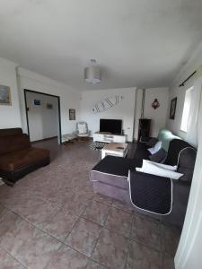 a living room with a couch and a tv at Villa Jopati in Olho Marinho