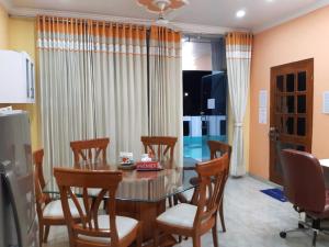 een eetkamer met een tafel en stoelen bij Homestay - Serviced Apartment "ISH Atithya" with Modular Kitchen, various amenities and Complimentary Breakfast in Lucknow, IN in Lucknow