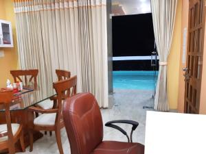 een woonkamer met een tafel, stoelen en een televisie bij Homestay - Serviced Apartment "ISH Atithya" with Modular Kitchen, various amenities and Complimentary Breakfast in Lucknow, IN in Lucknow