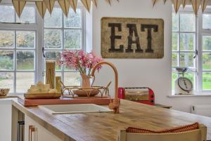 a kitchen with aeat sign on the wall at Priory Coach House in Pagham