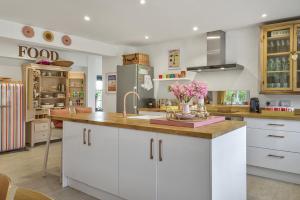 a kitchen with white cabinets and a counter with flowers on it at Priory Coach House in Pagham