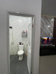 ein Badezimmer mit einer weißen Toilette in einem Zimmer in der Unterkunft Casa de Bella BnB in Mataram