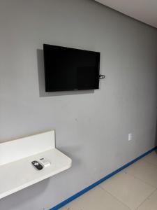 a flat screen tv hanging on a white wall at Brasil hotel in Canaã dos Carajás