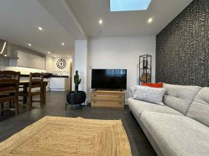 a living room with a couch and a television at Contractor & Leisure Stay 4BR all en-suite and Parking in Portsmouth