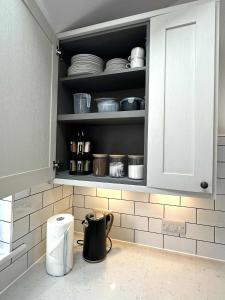 d'une cuisine avec une armoire munie de vaisselle. dans l'établissement Brain Properties Limited - Garden flat with Parking near QA Hospital, à Portsmouth