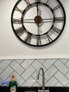a clock on the wall above a kitchen sink at Contractor & Leisure Stay 4BR all en-suite and Parking in Portsmouth