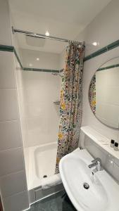 a bathroom with a sink and a tub and a mirror at Hotel Der Tannenbaum in Munich