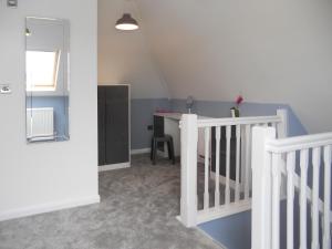 a room with a crib and a desk in it at The Cob Barn - Ukc1852 in Shaldon +3 photos