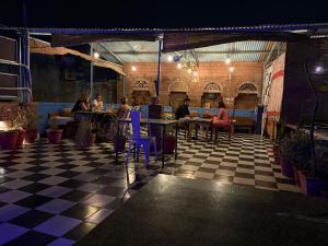 un groupe de personnes assises à des tables dans un restaurant dans l'établissement Geel Heritage - A Restored Haveli, à Jodhpur 60 autres photos