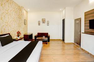 a hotel room with a bed and a chair at Hotel O Raj Ambessy in Rāmpura