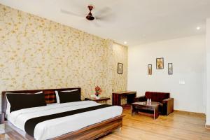 a bedroom with a large bed and a living room at Hotel O Raj Ambessy in Rāmpura