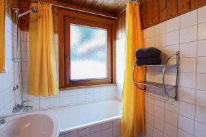 a bathroom with a tub and a sink and a window at Ferienbungalows MOHR in Sankt Jakob in Defereggen +77 photos