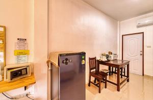 a kitchen with a stainless steel refrigerator and a table at The Bulin Residence in Lamai