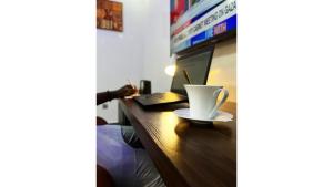 a table with a coffee cup and a laptop on it at GPR Suites & Apartments in Aso