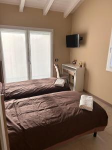 NervianoにあるRiVaLoVEのベッド2台と机と窓のある寝室