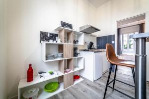 a kitchen with white shelves and a chair in a room at Le Valet - 1 Chambre in Brive-la-Gaillarde +9 photos