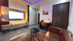a living room with a couch and a tv on a wall at GPR Suites & Apartments in Aso