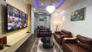 a waiting room with leather couches and a tv at GPR Suites & Apartments in Aso