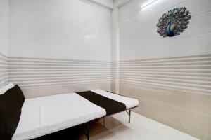 a small room with a bed and a decoration on the wall at SPOT ON Radhakund Guest House in Rādha Kund