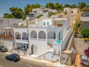 una casa bianca con macchine parcheggiate di fronte di Marinaia Archi a Marittima