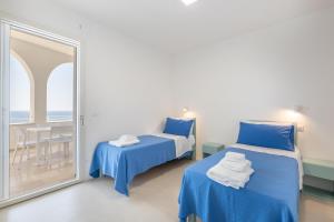 una stanza con due letti e una grande finestra di Marinaia Archi a Marittima